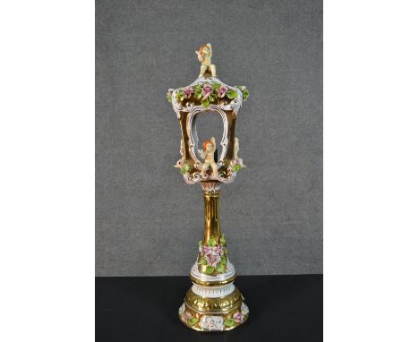 A 20th century Capodimonte table lamp, in the form of a lantern, encrusted with flowers, parcel gilt and mounted with cherubs