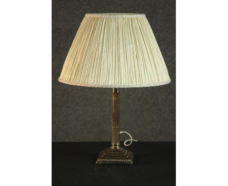 A silver plated Classical column candlestick, converted to a table lamp, with a square step-down base and a pleated shade. H.