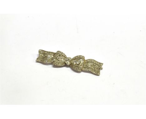 AN EDWARDIAN PLATINUM AND DIAMOND BOW BROOCH the principle stone at the centre approx. 0.33cts, within a surround of old-cut 