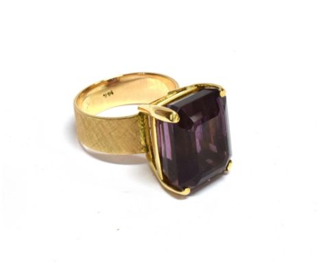 AN ORIENTAL YELLOW METAL AND RECTANGULAR AMETHYST SINGLE STONE RING  the step-cut stone approx. 15.8mm x 12.8mm, in a four-cl