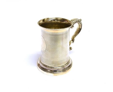 A VICTORIAN SILVER ENGINE-TURNED, STRAIGHT-SIDED PINT MUG with a leaf-capped double-scroll handle, on a stepped moulded foot,