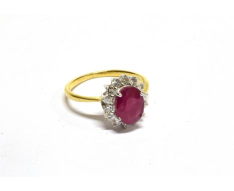 A MODERN 18CT GOLD, RUBY AND DIAMOND OVAL CLUSTER RING  centred with a pinkish-red, oval mixed-cut ruby, approx. 1.40cts, wit