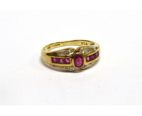 A MODERN 9CT GOLD, RUBY AND DIAMOND DRESS RING centred with an oval mixed-cut ruby between calibre ruby three stone bands and