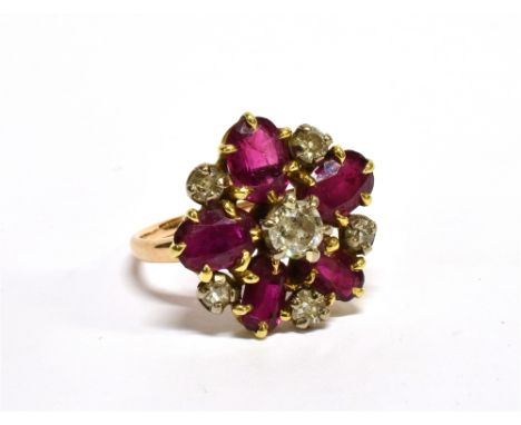 AN EARLY 20TH CENTURY GOLD, RUBY AND DIAMOND CLUSTER RING with a central old-cut diamond, approx. 0.30cts, within five oval m