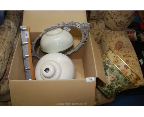 A pretty oval mirror, metal lamp shade, glass globe lamp shade and a wall mounted coat rack.