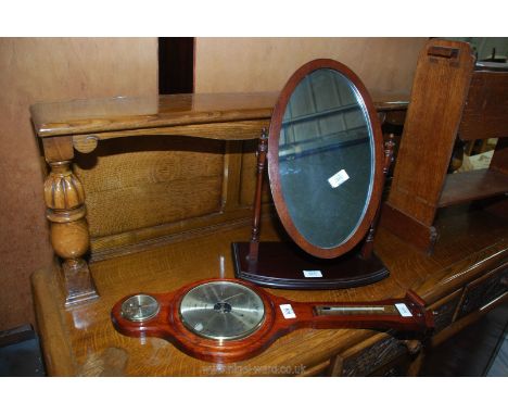 A small banjo style barometer and an oval dressing table mirror.