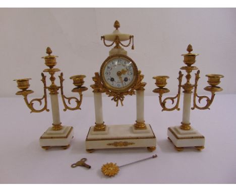 A French white marble and gilded metal mantle clock with white enamel dial and Arabic numerals flanked by two light candelabr