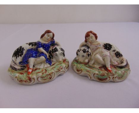 A pair of Staffordshire ceramic figurines of young ladies with dogs