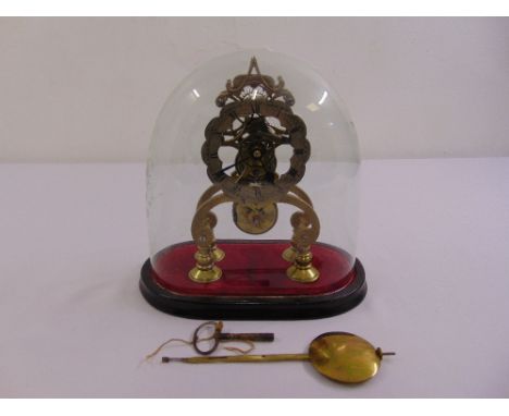 A 19th century brass skeleton clock, the enamel dial with Arabic numerals in original glass dome and oval wooden base to incl