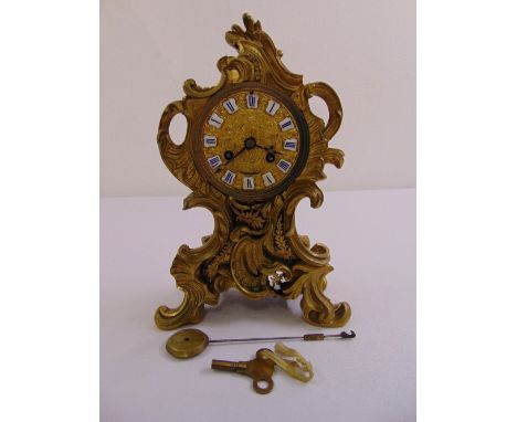 A French gilded metal Rococo style mantle clock, to include pendulum and key
