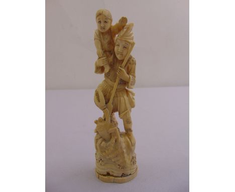 A late 19th century Japanese ivory figurine of a man carrying a child