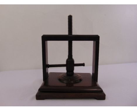 A Victorian mahogany book press of customary form on rectangular base with bracket feet