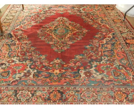 A Persian carpet, having central medallion on a red madder ground. L.370cm W.260cm