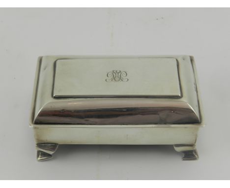 An Edwardian silver tabletop pin box, the hinged top monogrammed and enclosing a moire silk interior, raised on ogee bracket 