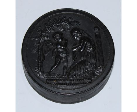 A 19th century pressed horn circular snuff box, the push-fitting cover in relief with Cupid and Psyche, engine-turned base, 6
