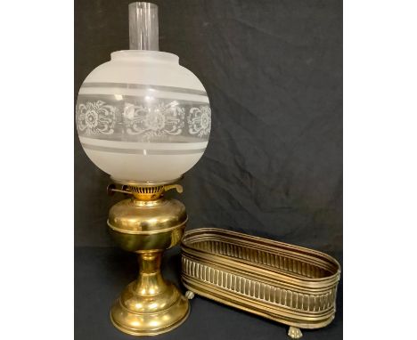 A brass oil lamp with etched glass globe; a brass jardinière 