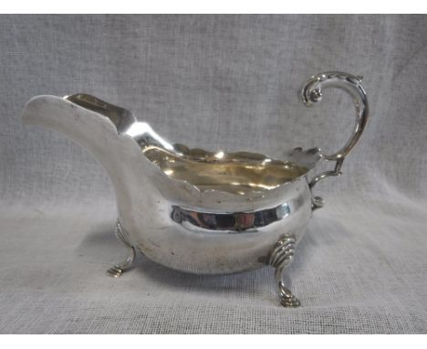 A SHEFFIELD SILVER GEORGE III STYLE SAUCE BOAT on four hoof feet