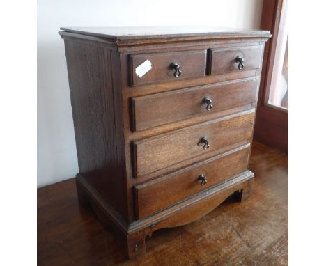 A VICTORIAN MINIATURE OAK CHEST OF DRAWERS, with shaped bracket feet, 14" high x 12.25" wide