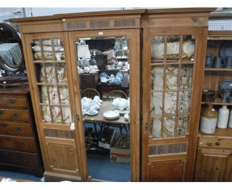 MAPLE & CO: AN EDWARDIAN STRIPPED PINE BREAK-FRONT TRIPLE WARDROBE, with central mirrored door enclosing drawers and flank gl