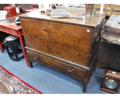 AN 18TH CENTURY OAK TRUNK ON STAND, fitted brass carrying handles, the base fitted a single drawer, 41" wide 