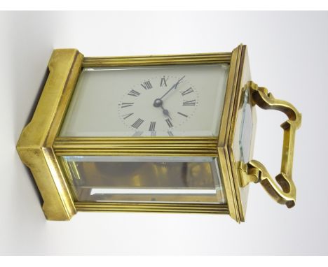 Early 20th century brass and bevel glazed carriage clock time-piece, reeded uprights enclosing Roman dial, eight day movement