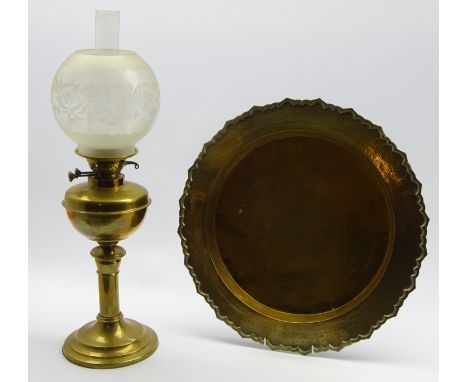 Brass table oil lamp with circular foot and etched glass shade H64cms overall and an Eastern engraved brass tray 47cms Diam.