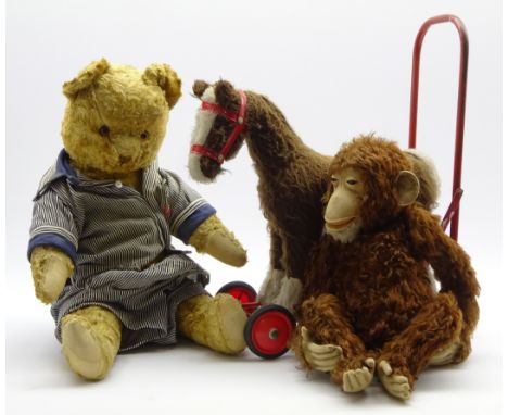 Steiff monkey in brown mohair and ear button H46cms, a plush covered teddy H64cms and a child's push-along toy horse Conditio