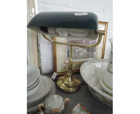 A brass desk lamp with green shade
