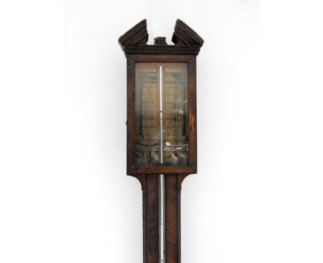 A walnut stick barometer, 18th century with architectural pediment and rectangular glazed door enclosing a classical paper la