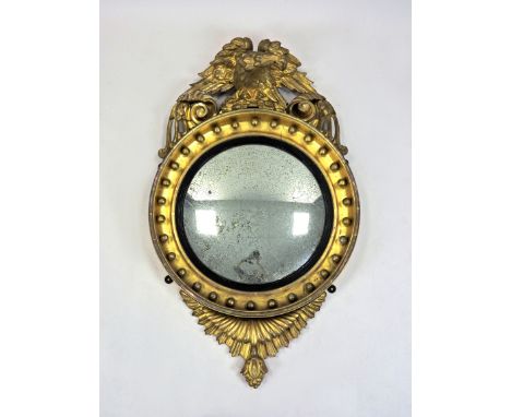 A William IV gilt framed wall mirror, second quarter 19th century, the convex circular glass within a black slip frame and gi