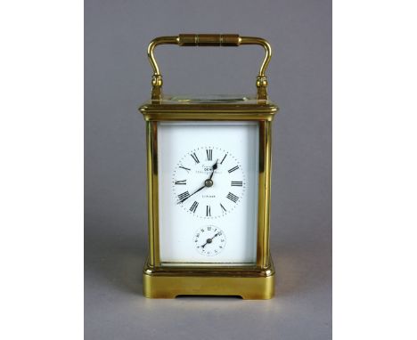 A gilt brass cased carriage alarm clock, the bevelled five glass case with white enamel dial, Roman numerals and marked 'Exam