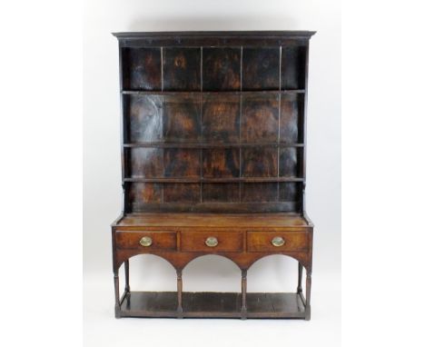 A George III oak pot board dresser, late 18th century, with canopied rack and iron hooks and slots in the upper shelf for spo