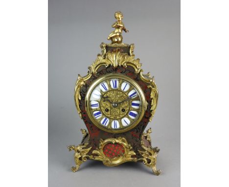 A Louis XV style scarlet boulle and ormolu mounted mantle clock, 19th century, the five inch dial with blue enamel chapters a