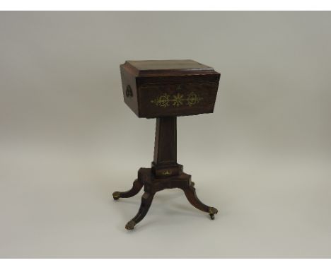 A Regency rosewood and brass inlaid teapoy, early 19th century, the sarcophagus top enclosing two lidded tea caddies and two 