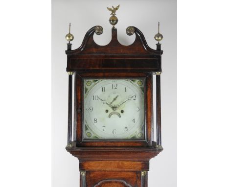 A George III oak and mahogany cross banded longcase clock with broken scroll pediment and a ball and eagle finial and two bal