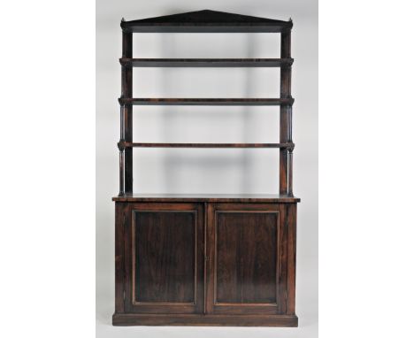 A William IV rosewood waterfall cabinet bookcase, the architectural canted cornice above four graduated shelves spaced by tur