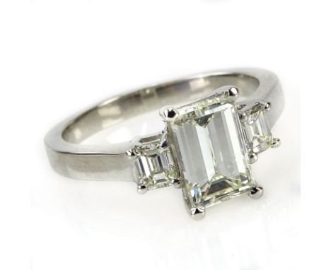 Approx. 1.92 Carat TW Diamond and Platinum Engagement Ring. Set in the center with an approx. 1.55 carat emerald cut diamond 