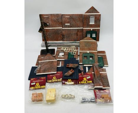 A small collection of G Scale model railway accessories including a building, signal, several packaged Bachman Big Haulers it