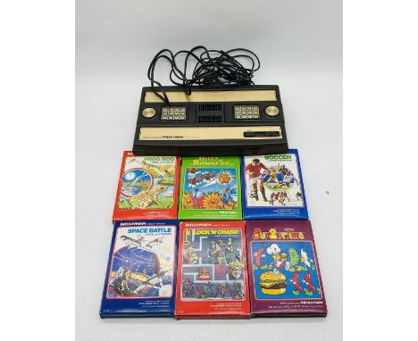 A Mattel Electronic Intellivision Intelligent Television gaming console, along with six games including Space Battle, Burger 
