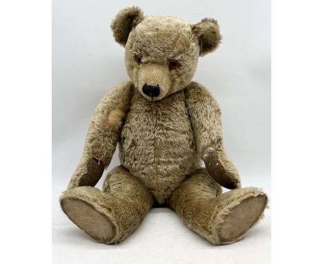 A large Chiltern Hugmee teddy bear circa 1930's in blonde mohair with glass eyes, jointed arms and legs and swivel head. Some