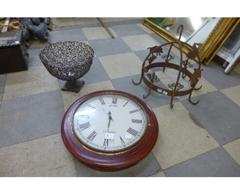 A circular wall clock, a metalwork board and a decorative metalwork rack