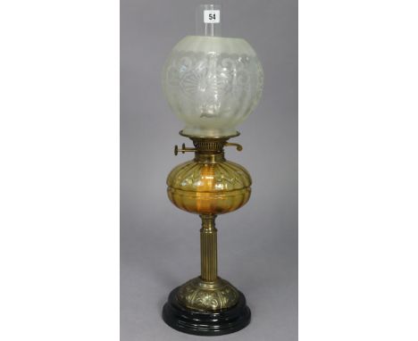 A Victorian brass oil table lamp with amber tinted glass reservoir, &amp; with an etched glass globular shade, 24½” high. 