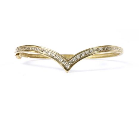 A 9ct gold diamond wishbone bangle, the 'V' shaped upper half grain set with eight cut diamonds, to a plain polished lower ha
