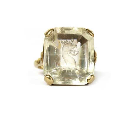 A gold intaglio engraved smoky quartz ring, with a mixed cut smoky quartz intaglio engraved with a crest, a griffin or eagle'