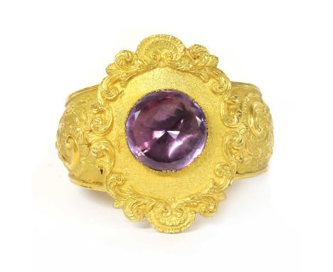A Victorian gilt metal amethyst bangle, with a circular mixed cut foil backed amethyst, to an oval ground with scroll edge, t