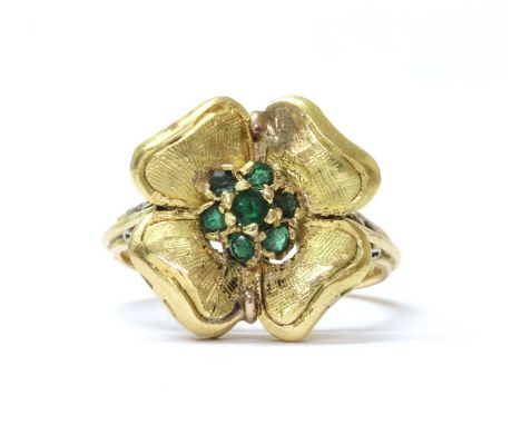 A gold emerald cluster ring, with a cluster of mixed cut emeralds, claw set to the centre of the flower form head, to open sh