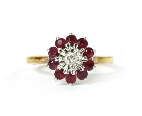 An 18ct gold diamond and ruby cluster ring, with a brilliant cut diamond grain set to an illusion collet, to surround of roun