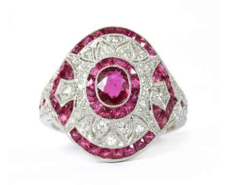 A platinum ruby and diamond ring, the slightly curved oval head with an oval mixed cut ruby milligrain set at the centre, wit