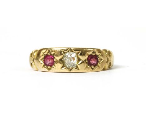 A gold diamond and ruby three stone ring, with an old cut diamond with a mixed cut ruby at each side, all star set to scroll 