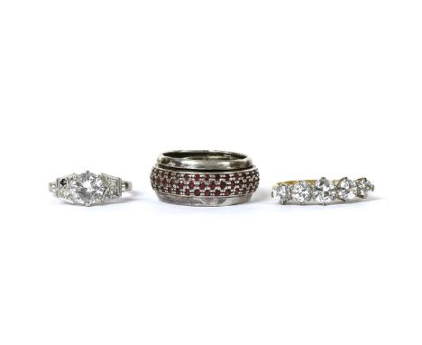 Three rings, to include a five stone paste ring, ignore markings, a white metal single stone paste ring with paste set should